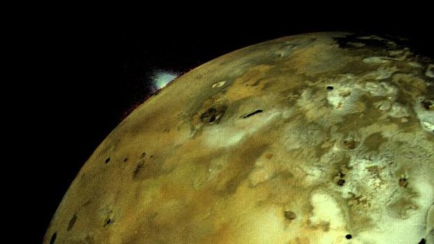 A photo of Io with a huge volcanic eruption visible from space.