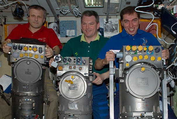 Russian cosmonauts with oxygen generator systems on the International Space Station.