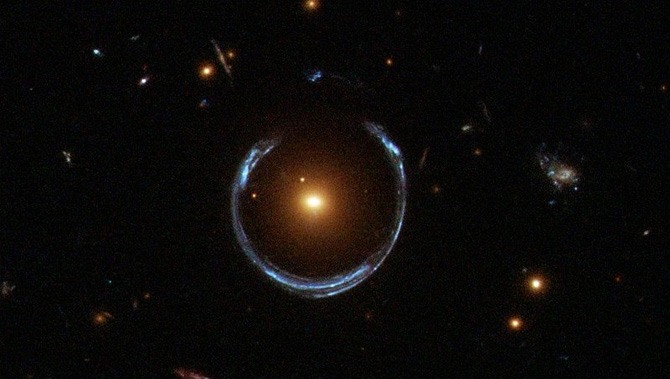 Space photograph showing a horseshoe-shaped ring of light around a bright point of light.