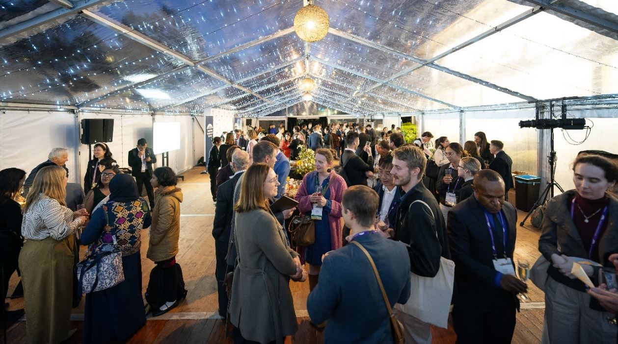 Young adults socialising at an evening event in a marquee