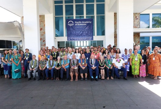 Large group of people seated and standing outside a building