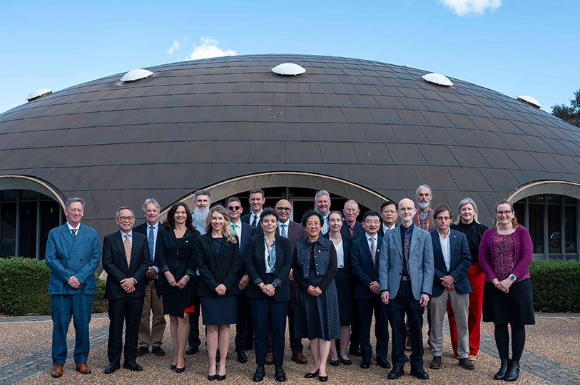 A group of 20 or so people pose for a group photo in front of the Shine Dome