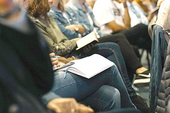 Uni students with books on their lap.