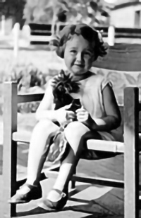 Smiling small girl on a chair (black and white photo)
