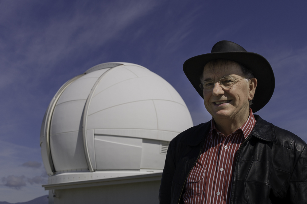 Smiling man stands in front of observatory