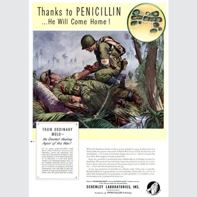 Printed page with colour drawing of a wartime scene in the tropics showing an army medic injecting into the arm of an injured soldier on the ground, and also an inset drawing showing magnified microbes. Text on the page includes the heading 'FROM ORDINARY MOLD - the Greatest Healing Agent of this War!'